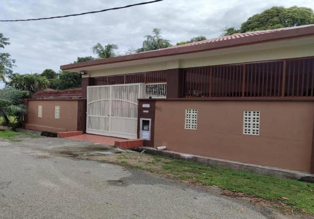 une maison brune avec un portail et une allée. dans l'établissement BUTIK VILLA, à Port Dickson