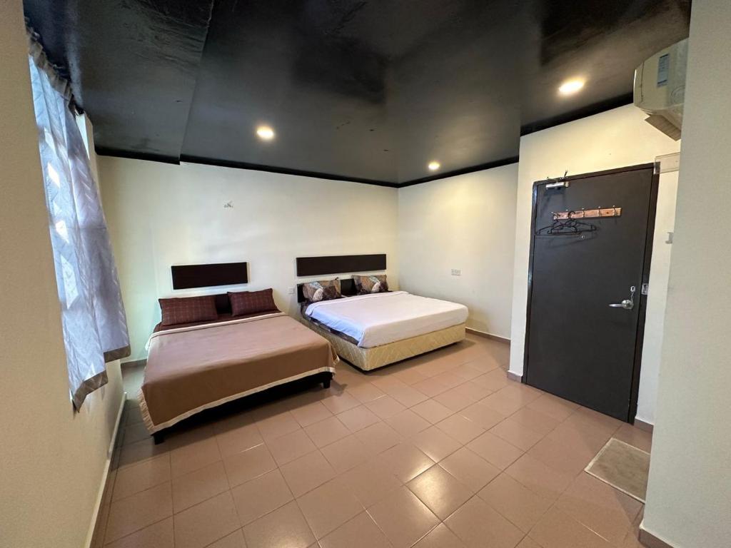 Postel nebo postele na pokoji v ubytování Ezzy In Hotel