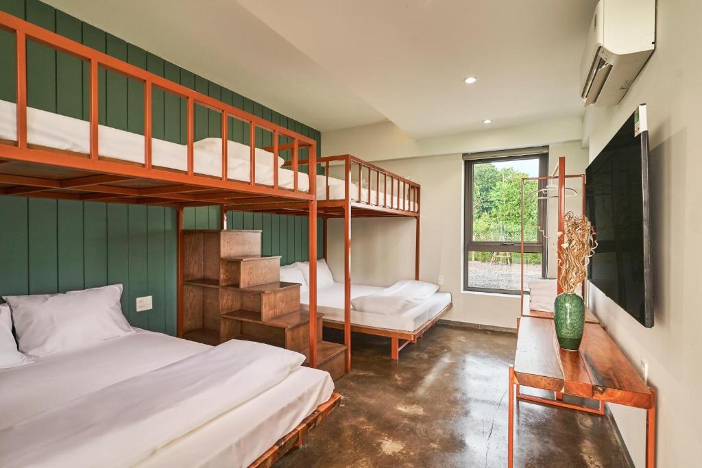 1 Schlafzimmer mit 2 Etagenbetten und einem Fenster in der Unterkunft BEAUCHAMP VILLA in Ấp Bình Yên