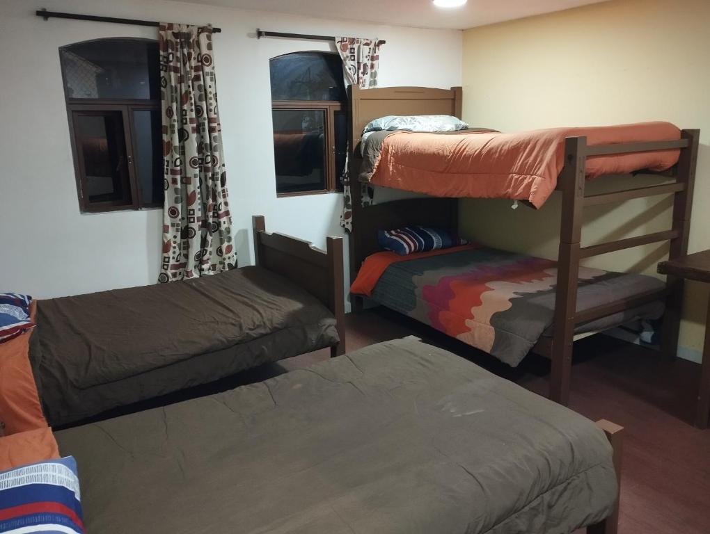 a dorm room with bunk beds and a chair at Hotel Tradiciones Quito Foch in Quito