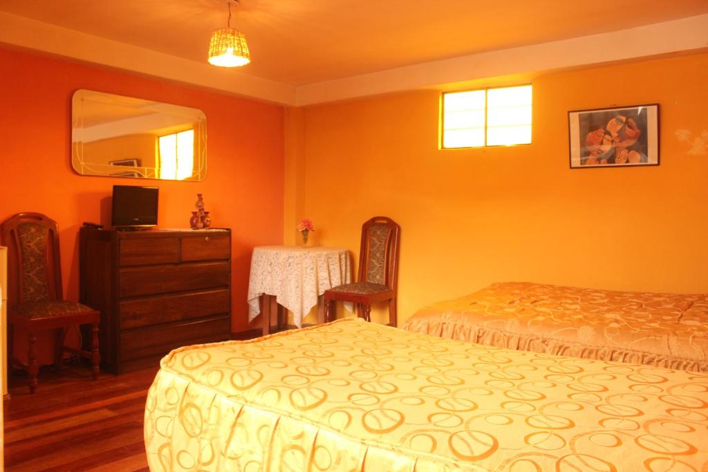 a bedroom with two beds and a dresser and a mirror at Casa de Mama Cusco 2-The Ecohouse in Cusco