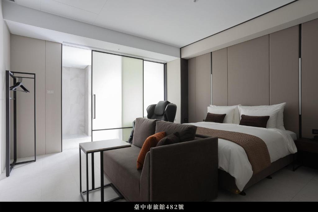 pokój hotelowy z łóżkiem i kanapą w obiekcie Manho Hotel w mieście Taizhong