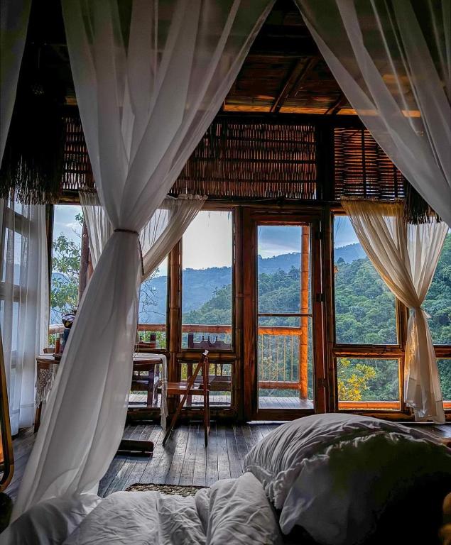una camera da letto con un letto e una grande finestra di Montelena Glamping a Vergara