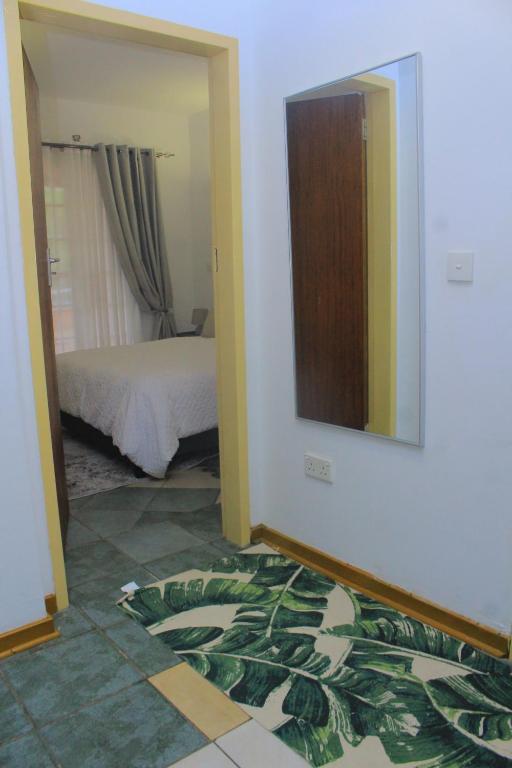 a bedroom with a bed and a mirror on the wall at Cozy stay in Gaborone