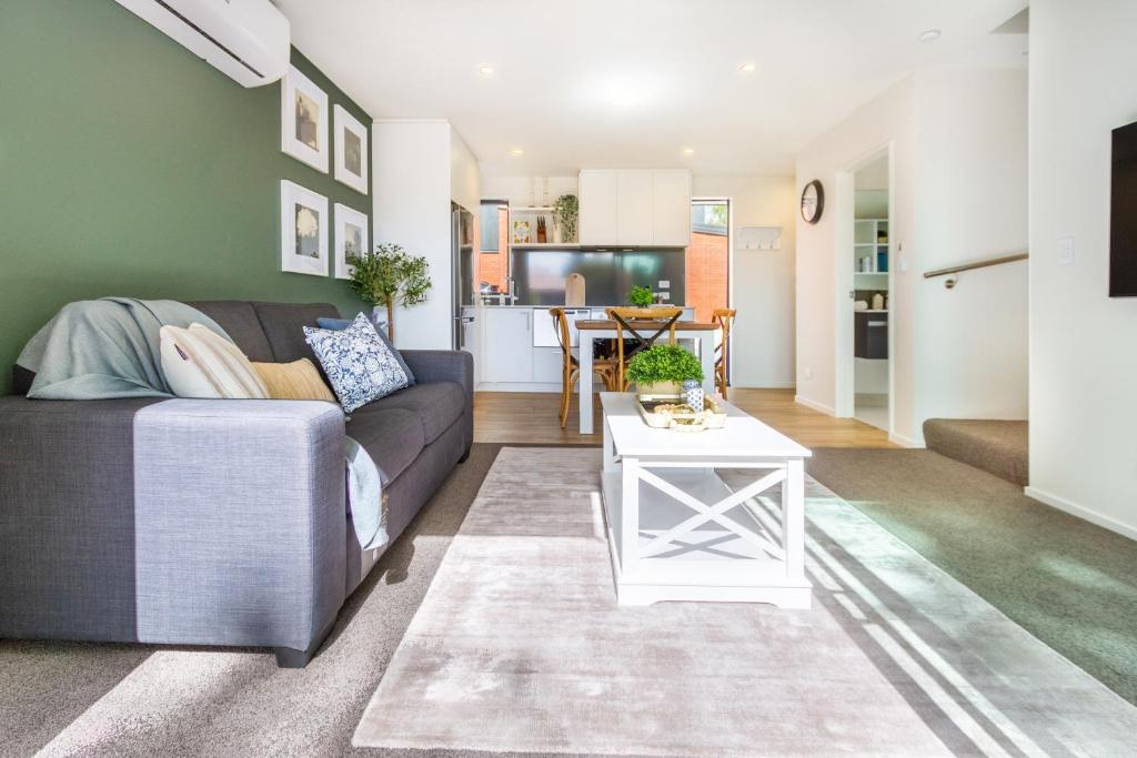 a living room with a couch and a table at Lovely in Linwood: 2BR Beauty in Christchurch