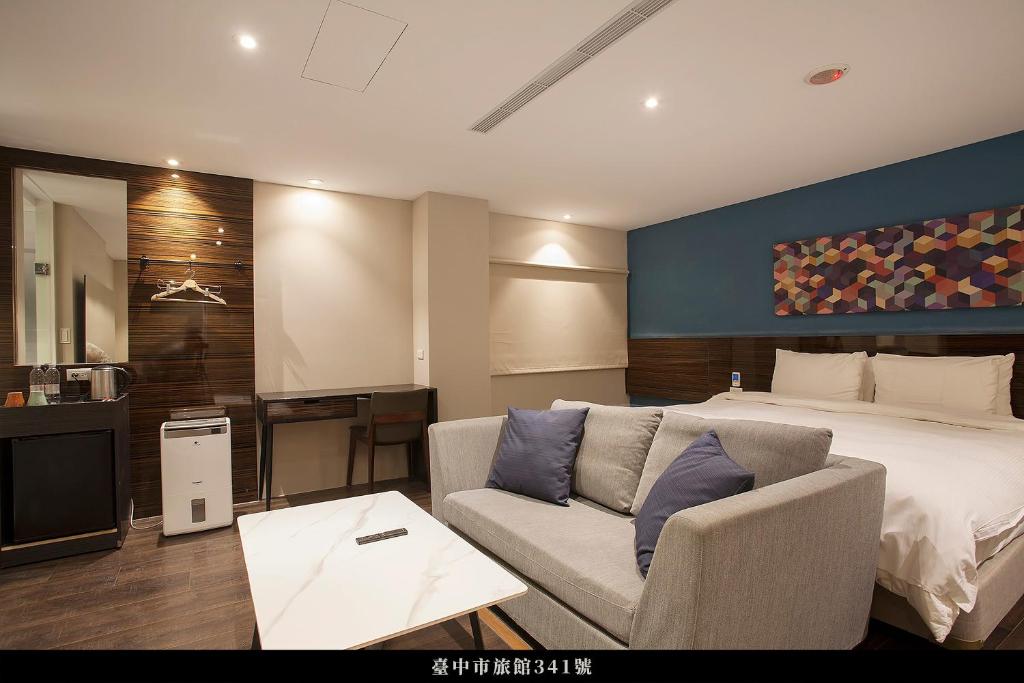 pokój hotelowy z łóżkiem i kanapą w obiekcie P&F Hotel w mieście Taizhong