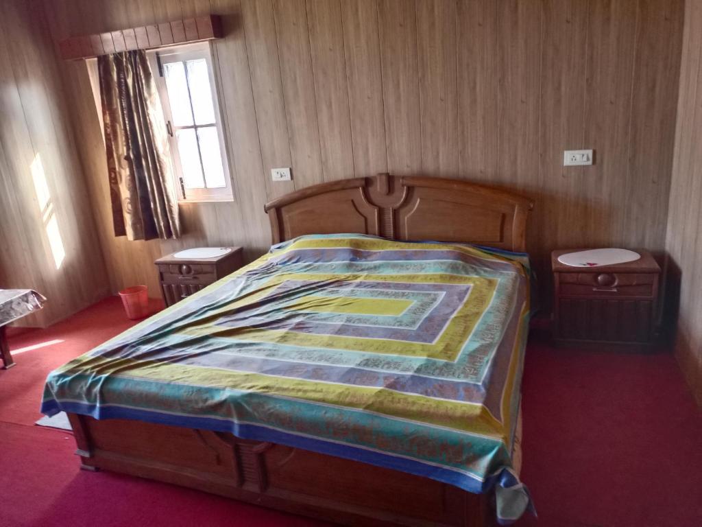 sypialnia z łóżkiem z kolorowym kocem w obiekcie OYO Home Ekant Kutir Homestay w mieście Kūd