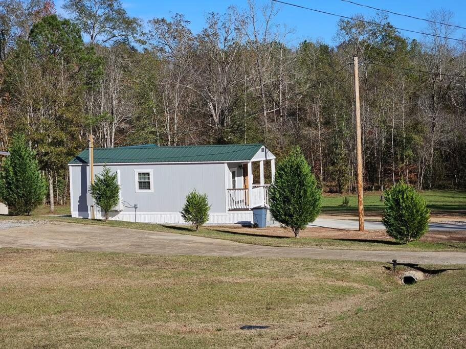 una piccola casa bianca con tetto verde di Studio 431-Vet owned 14 miles to Ft Moore a Phenix City