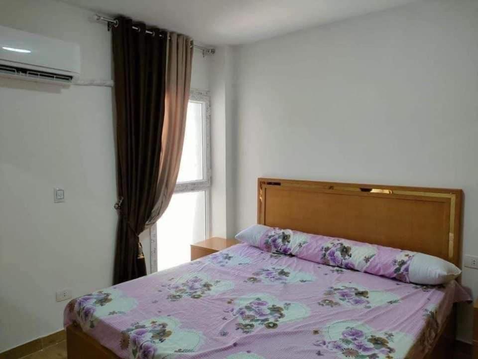 ein Schlafzimmer mit einem Bett mit einer lila Bettdecke und einem Fenster in der Unterkunft شاليهات مارينا دلتا ولاجونز in Al Ḩammād