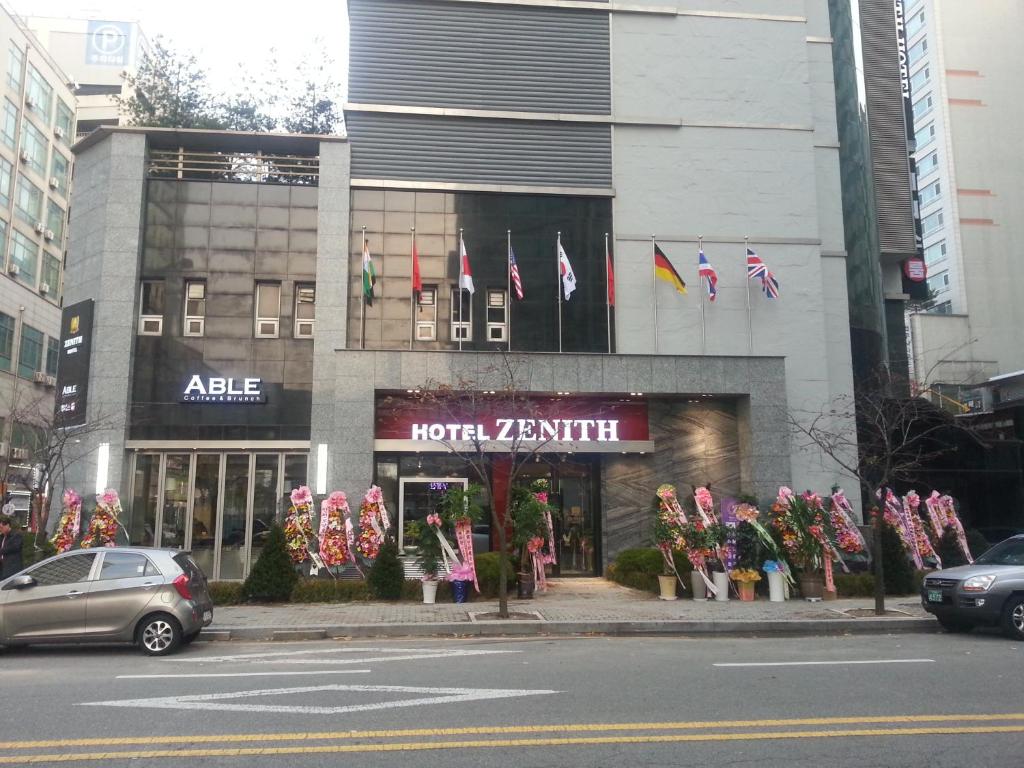 a store on a street with flags in front of it at Hotel Zenith in Bucheon