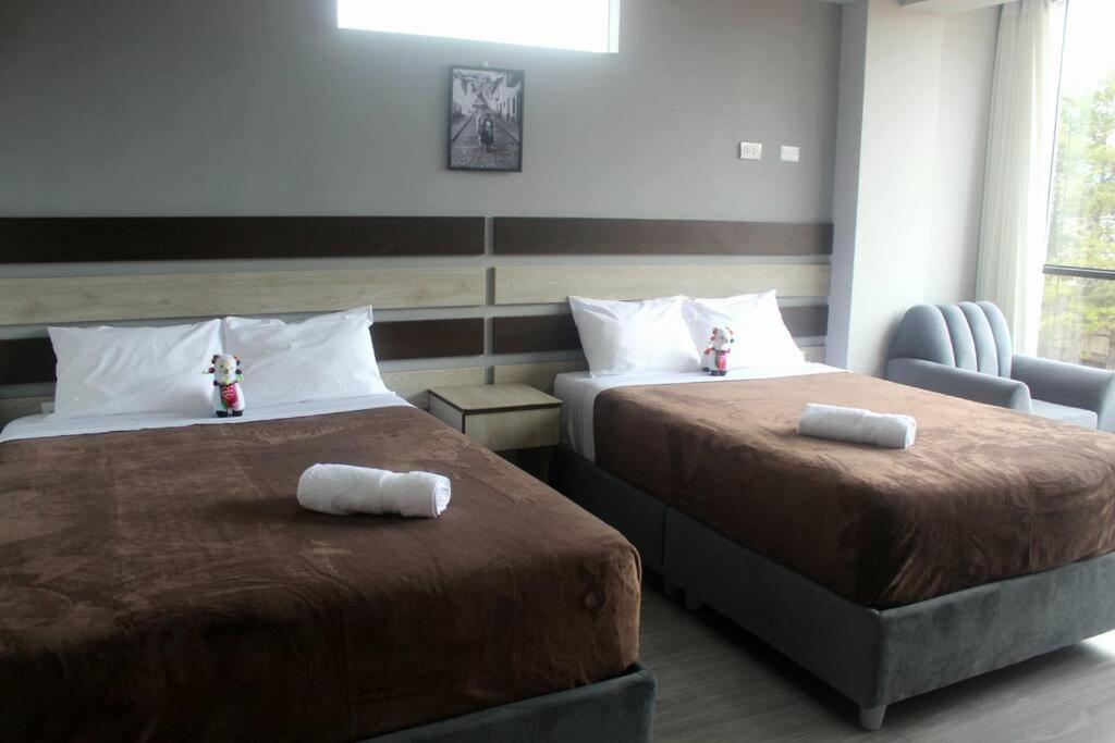 a hotel room with two beds with towels on them at ¡Departamento Puñuy Wasi! in Cusco