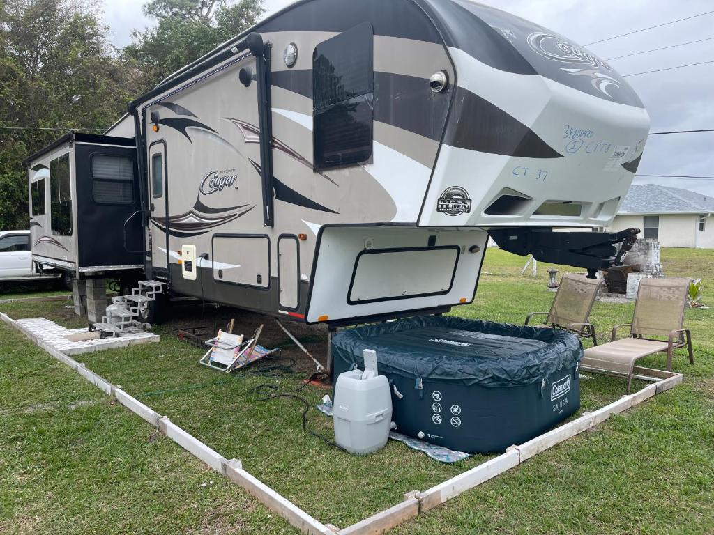 an rv is parked in a yard with a trash can at Entire 1bedroom RV Camper in Fort Pierce
