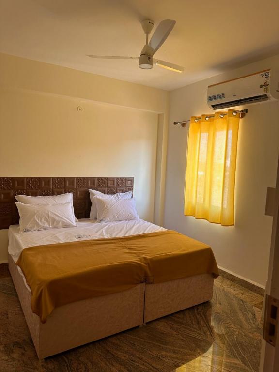 a bedroom with a bed with a ceiling fan at MPS Sai Palace in Tiruvannāmalai