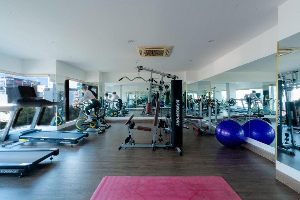 A mirrored strength-and-cardio gym centered on a multi-station cable machine.
