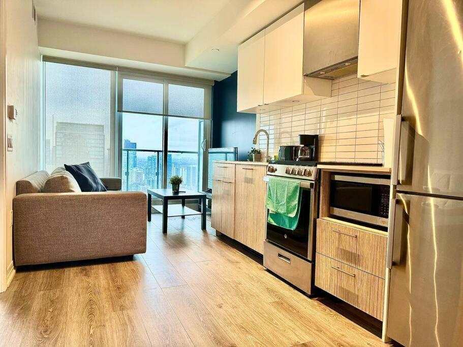 a kitchen with a couch and a stove top oven at Cozy Condo Near EatonCentre Mall in Toronto