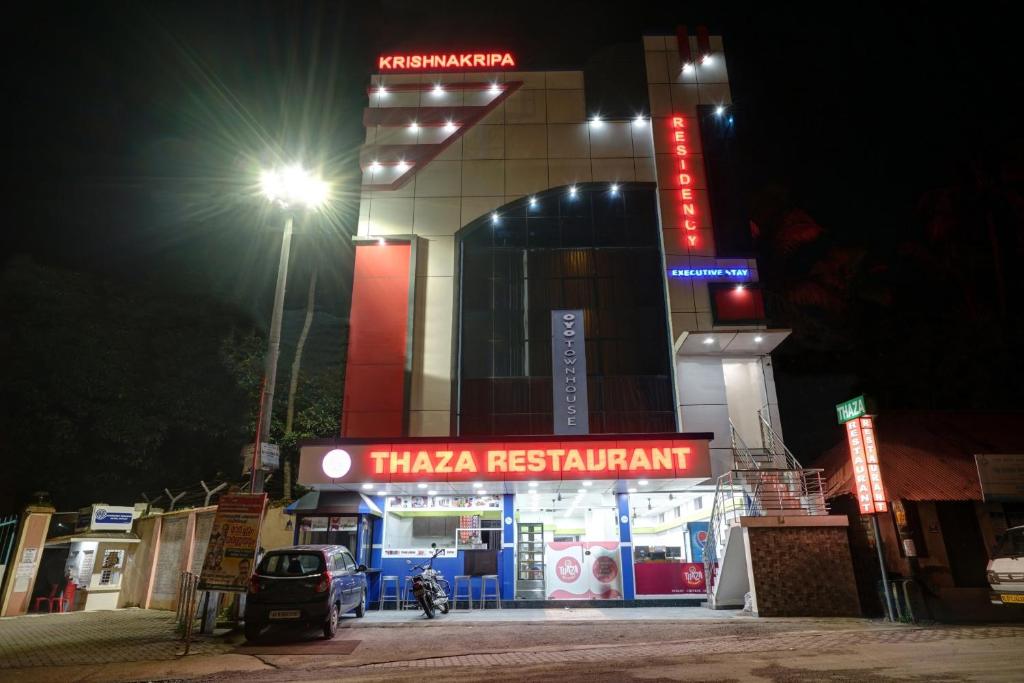 a taeria restaurant with a lit up sign at night at Super Capital O Krishnakripa Executive Stay in Muttam