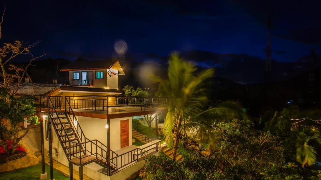 a house with a staircase leading up to it at night at Lamtam Maesa Resort ลำธารแม่สา รีสอร์ท in Mae Rim