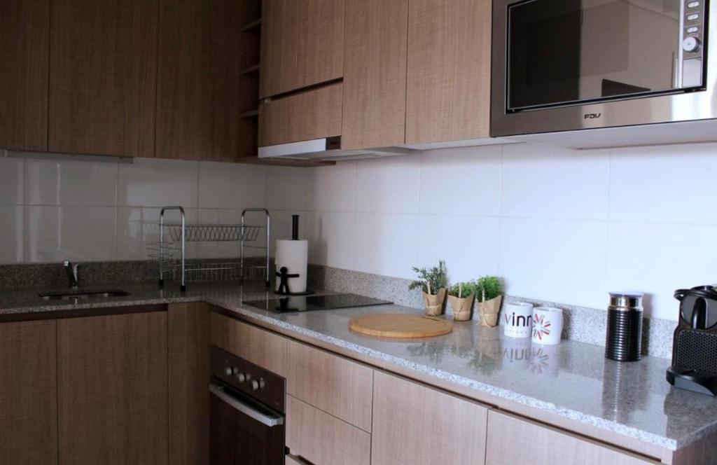 a kitchen with wooden cabinets and a counter top at Departamento Arequipa in Arequipa