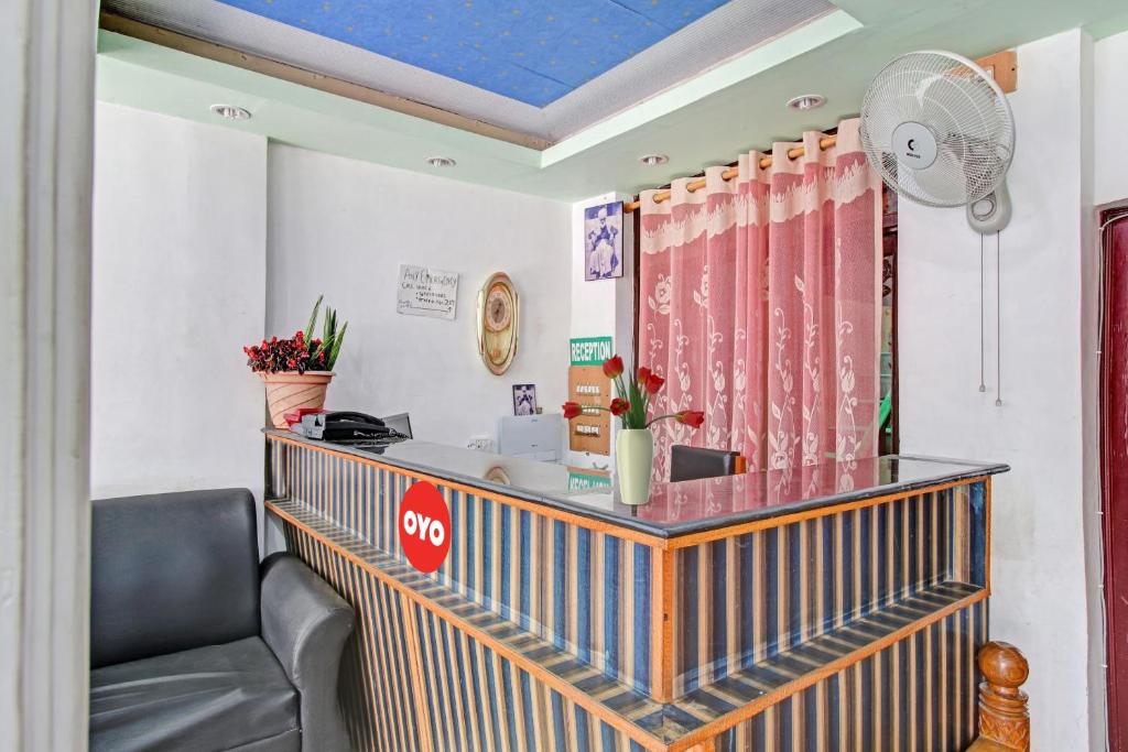 una sala de espera con una silla y un ventilador en OYO Hotel Jay Palace en Srinagar