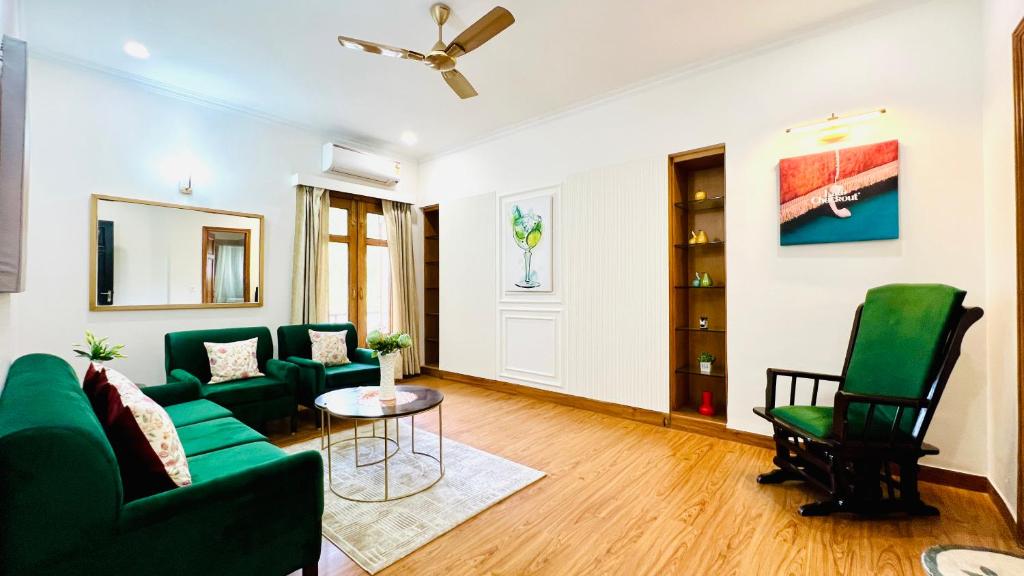 sala de estar con muebles verdes y ventilador de techo en BluO Vasant Vihar PVR - Kitchen, Terrace, Lift, en Nueva Delhi