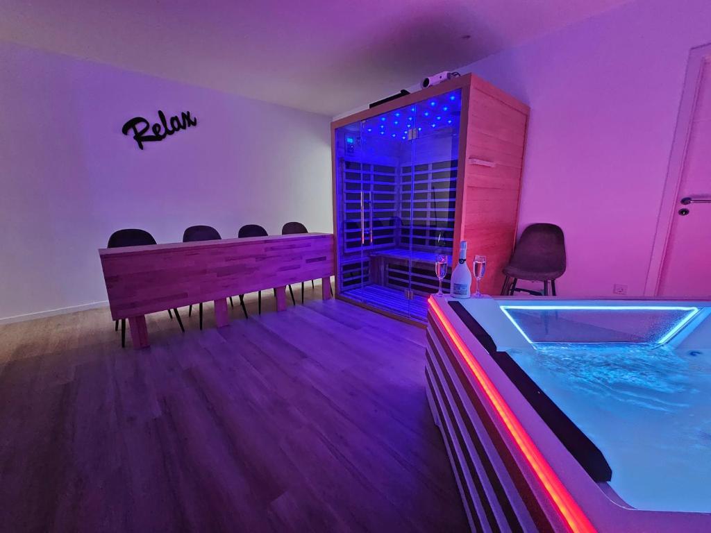 - une piste de danse avec une piscine dans une pièce dotée de lumières violettes dans l'établissement L'Appart Spa, Jacuzzi & Sauna, à Differdange