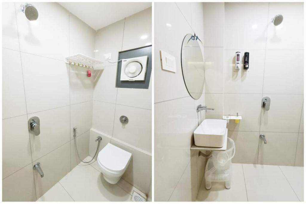 a white bathroom with a toilet and a shower at Hotel Kant - Best Hotel Near Shree Dwarkadhish Temple in Dwarka