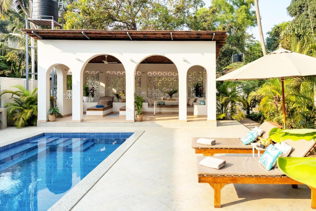 eine Terrasse mit einem Pool und eine Villa in der Unterkunft Villa Artjuna with private pool near Calangute in Saligao