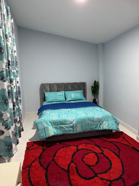 a bedroom with a bed with a red carpet at Bangli Homestay in Huma