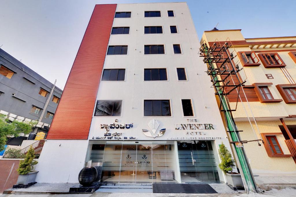 um edifício branco alto com um cartaz em The Lavender Hotel em Bangalore