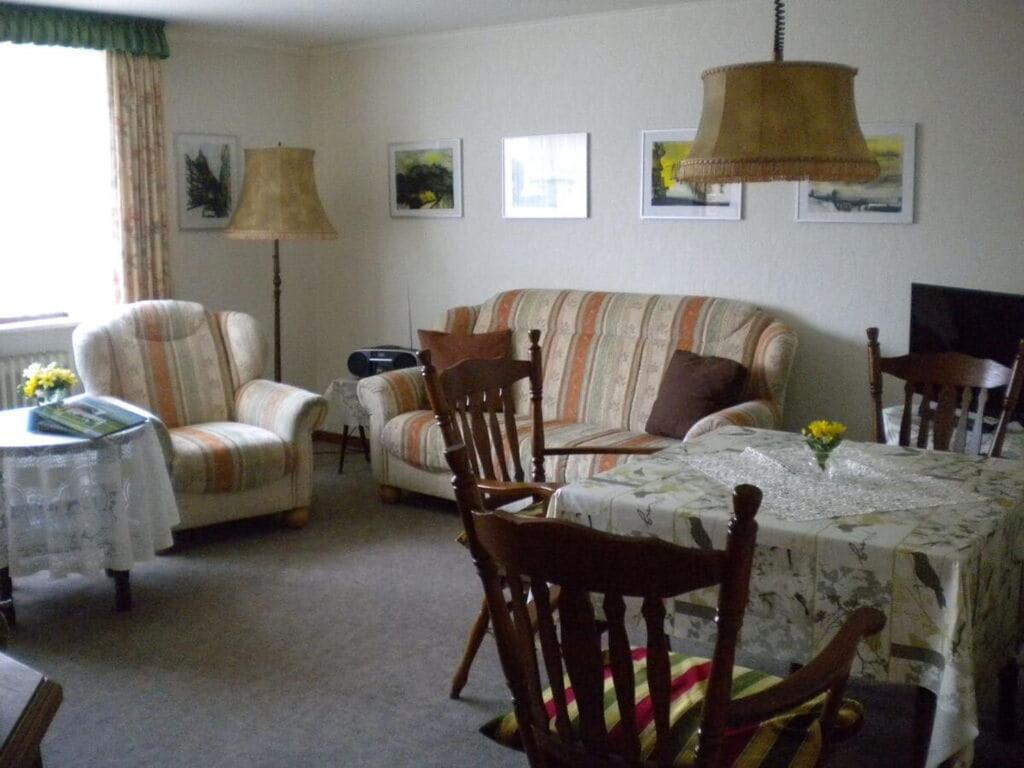 ein Wohnzimmer mit Tisch, Stühlen und Sofa in der Unterkunft North Sea dike Modern retreat in Sehestedt