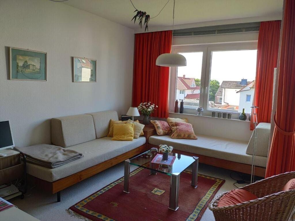 een woonkamer met een bank en een raam bij near the beach Modern retreat in Wangerooge