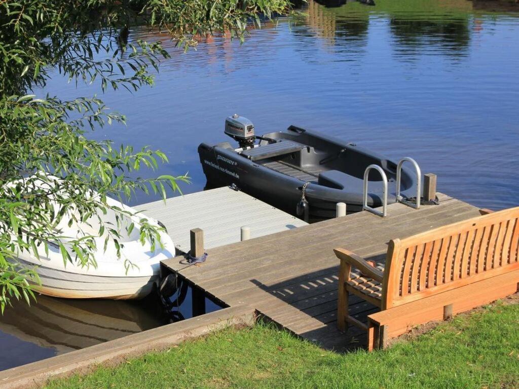 a boat is docked at a dock on the water at Övert Meer 6 Modern retreat in Timmel