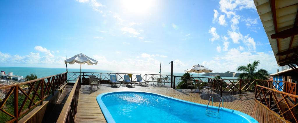 a swimming pool on a balcony with a view of the ocean at Marsallis Praia Hotel in Natal