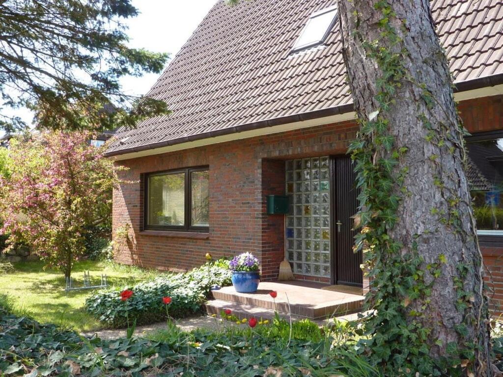 a brick house with a front door and a tree at Maiken Feikes, Am Friedrichshain 2 in Wenningstedt