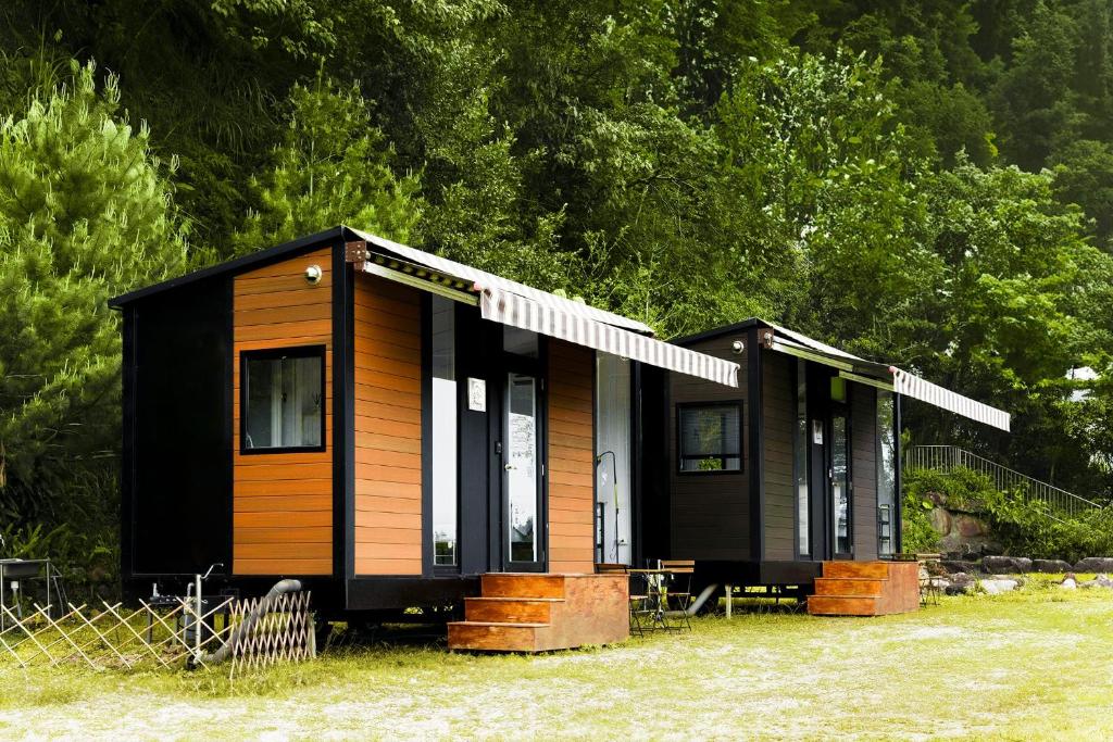 two black and brown modular homes in a field at Forest View Cottage 1 in Jiaoxi