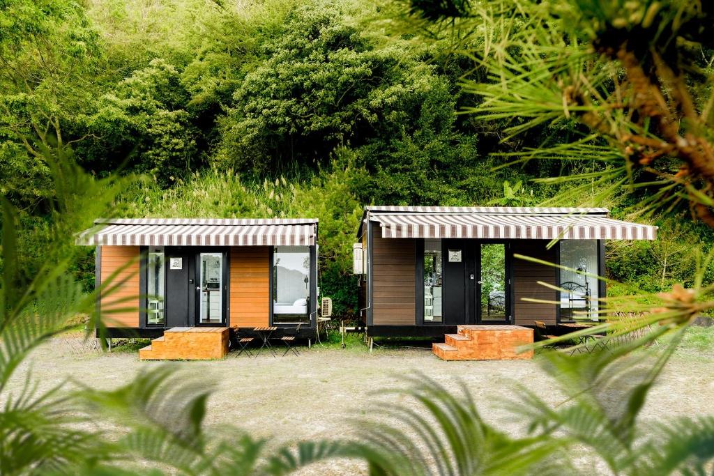 un par de casas pequeñas sentadas en la playa en Forest View Cottage 2 en Jiaoxi
