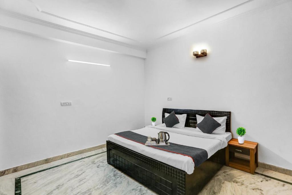 a bedroom with a bed in a white room at OYO Townhouse 1071 Hotel Metro Inn Residency Near ISKCON Temple Noida in Indirapuram