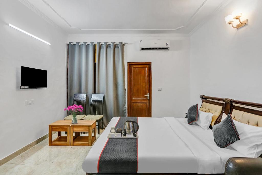 1 dormitorio con cama, mesa y TV en OYO Townhouse 1071 Hotel Metro Inn Residency Near ISKCON Temple Noida, en Indirapuram