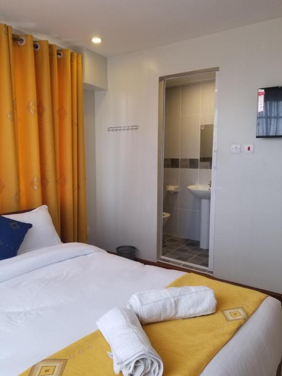 um quarto com uma cama com um espelho e um lavatório em 7 Days Holiday Inn em Nairobi