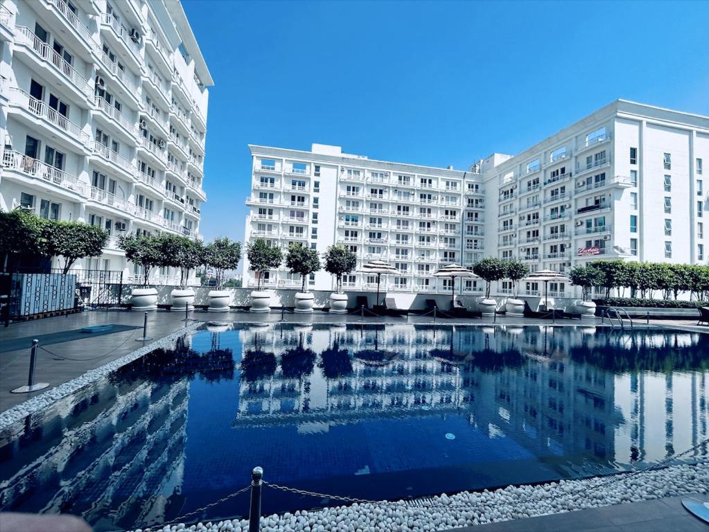 uma grande piscina em frente a dois grandes edifícios em Country Inn & Suites By Migrolino em Lucknow