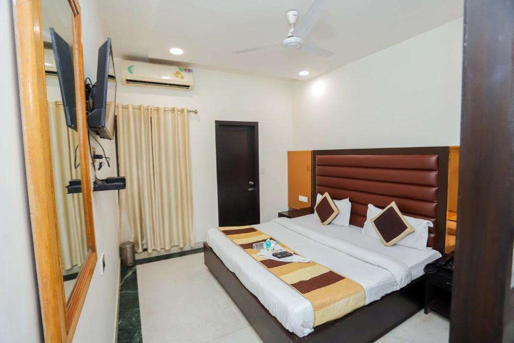 Habitación de hotel con cama y TV en Premium Inn near Sector 15 metro station, en Noida
