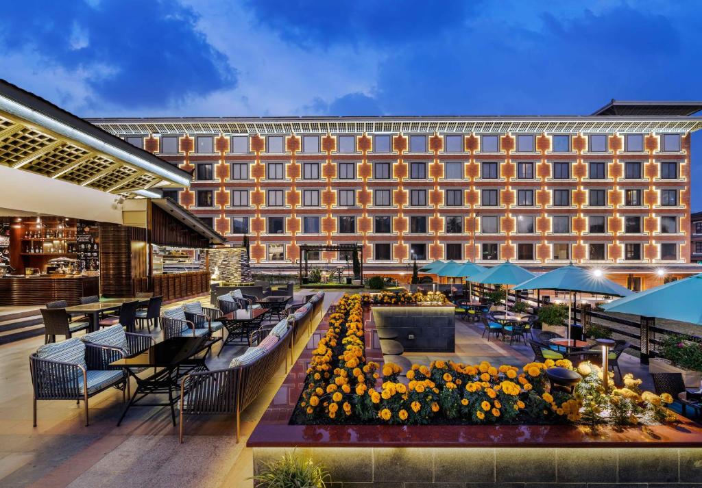 a hotel with a courtyard with tables and chairs at The Soaltee Kathmandu in Kathmandu