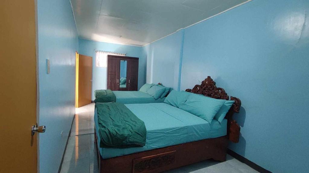 1 dormitorio con 1 cama con pared azul en Condons Beach House, en Caba