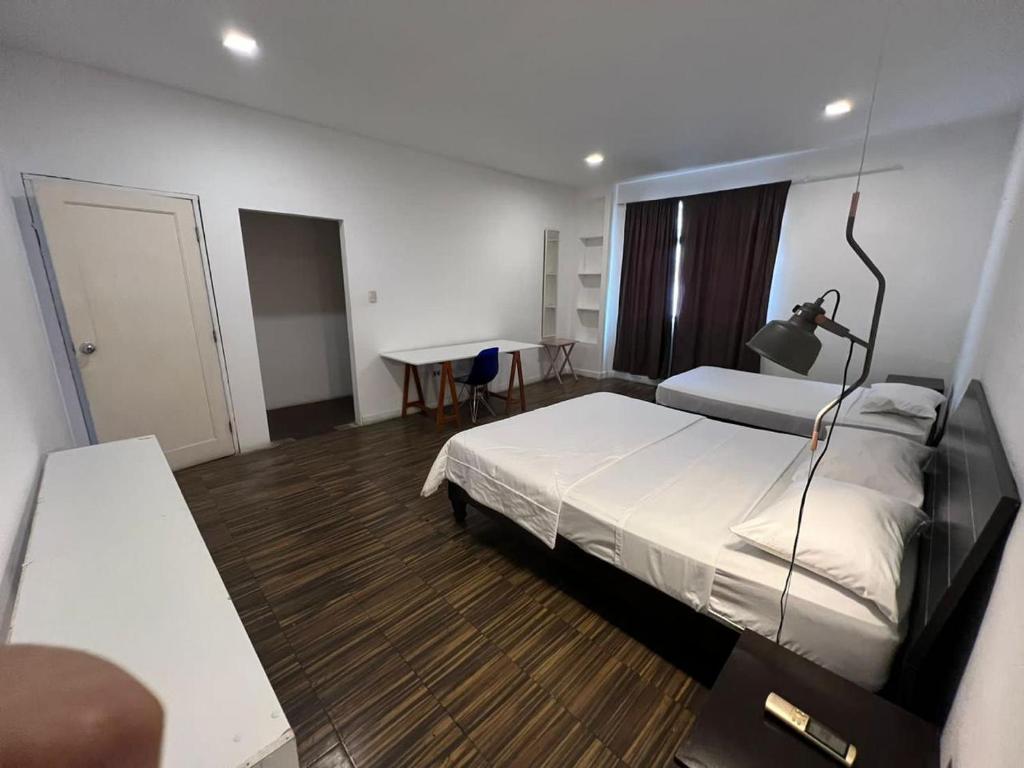 een slaapkamer met een bed, een bureau en een tafel bij Perla Suites Malecón in Guayaquil