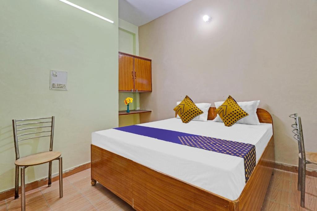 een slaapkamer met een groot bed en een stoel bij SPOT ON Ganpati Home Stays in Dehradun