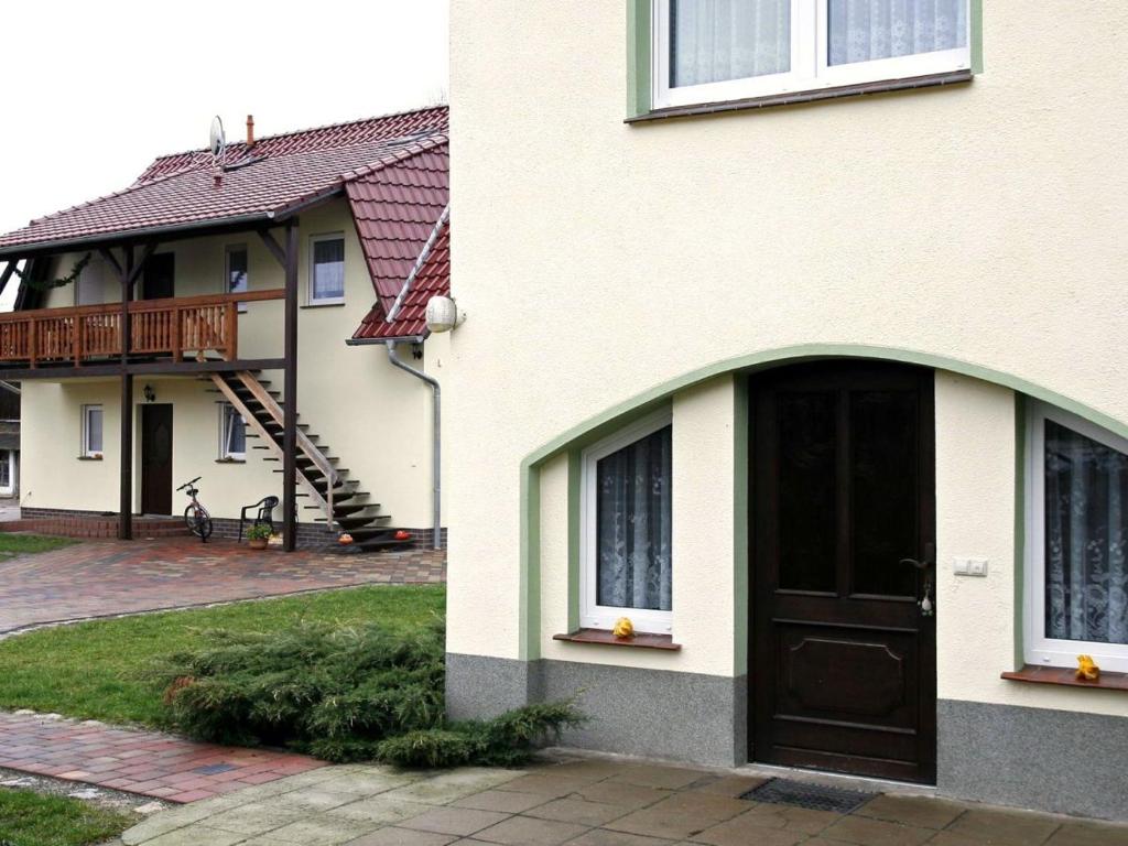 una casa con una porta marrone e un balcone di Ferienwohnung und Pension Jentsch a Markische Heide