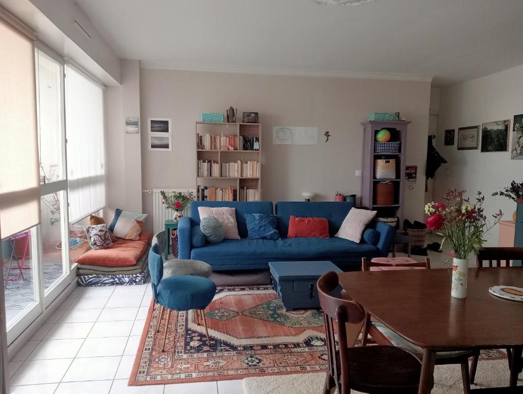 a living room with a blue couch and a table at Appartement lumineux et confort ! in Pantin
