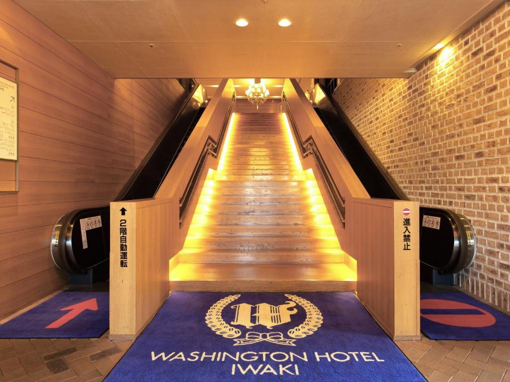 un long escalier roulant dans un bâtiment avec un panneau sur lequel figure un panneau dans l'établissement Iwaki Washington Hotel, à Iwaki