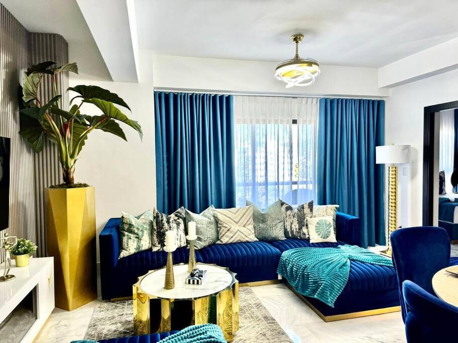 uma sala de estar com um sofá azul e uma mesa em Wendy Luxury Tower em Santiago de los Caballeros