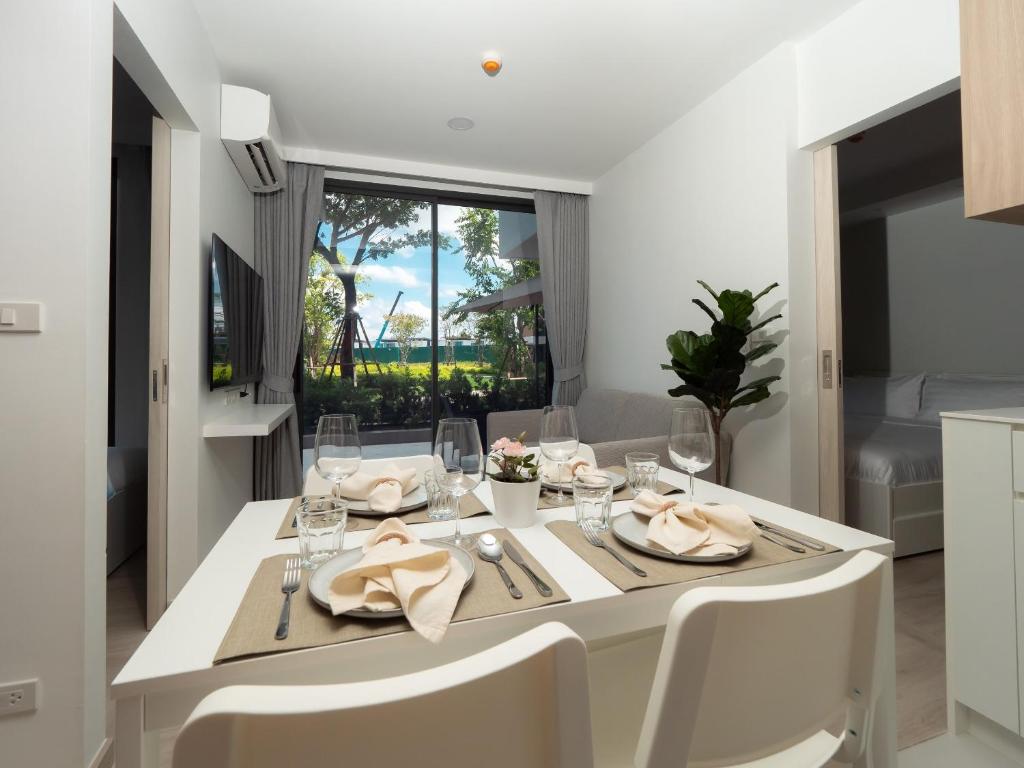 ein Esszimmer mit einem weißen Tisch und Stühlen in der Unterkunft Excellent 2bd apartment with a patio in Phuket